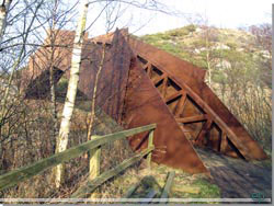 Bornholm. Kunstbroen, der fører over slugten ind til granitbruddet [Klik for et større billede]