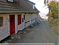 Bornholm. Ned ad gaden mellem huset og et hjt stengrde, s er jeg p havnen i Vang [Klik for et strre billede]