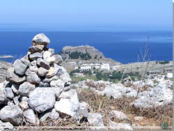 Bag varden anes byen Lindos med det antikke akropolis på klippetoppen Bag varden anes byen Lindos med det antikke akropolis på klippetoppen