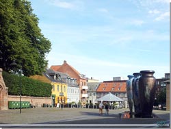 En god kop kaffe på den soloplyste del af det hyggelige torv med Roskilde Krukkerne