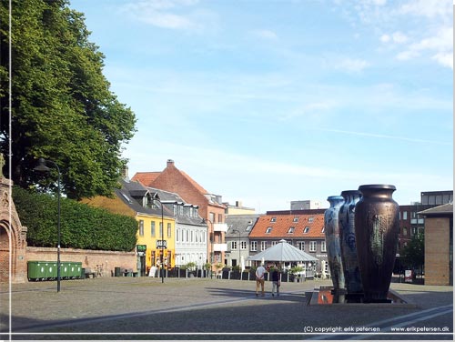 En god kop kaffe p den soloplyste del af det hyggelige torv med Roskilde Krukkerne