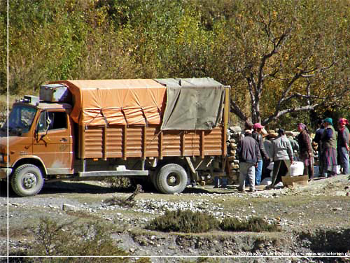 Nepal. Lngere fremme ad vejen holder en lastbil omgivet af folk. Der lsses varer af, der handles og diskuteres [copyright: Erik Petersen]