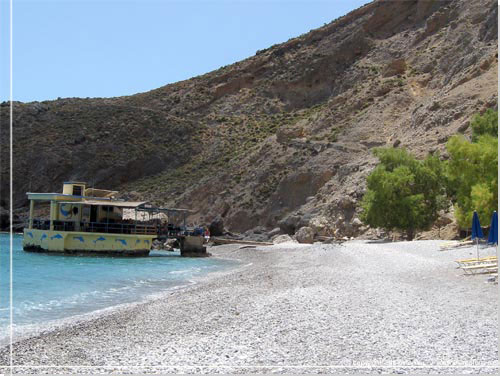 Sweet Water Beach og den flydende taverna. Sporet mod Loutro anes p bjergsiden bagved